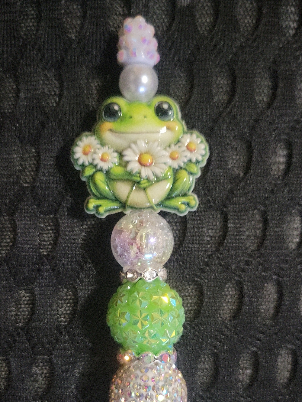 Handcrafted rhinestone beaded ballpoint pen featuring a cute frog holding daisie